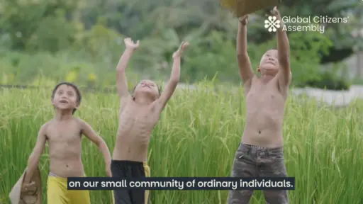Video still showing three young boys in a filed throwing their hats in the air.